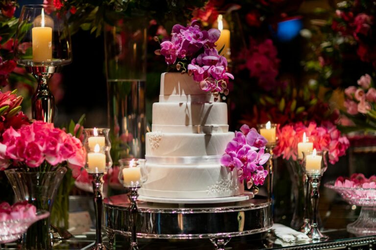 Scottsdale Wedding Catering Wedding Cake Decorated with Purple Orchid Flowers Wedding Event Catering Scottsdale by Bougie Chef- Wedding cake and flowers on a mirrored table